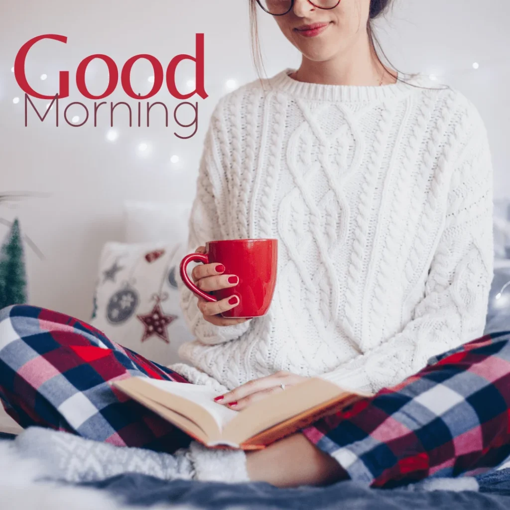 A blonde girl wear white sweater reading book holding red cup with coffee in the morning.png 2