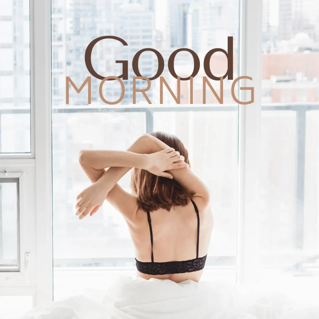 Blonde girl in a Bra stretching by folding arms sitting on bed in the morning.png 3