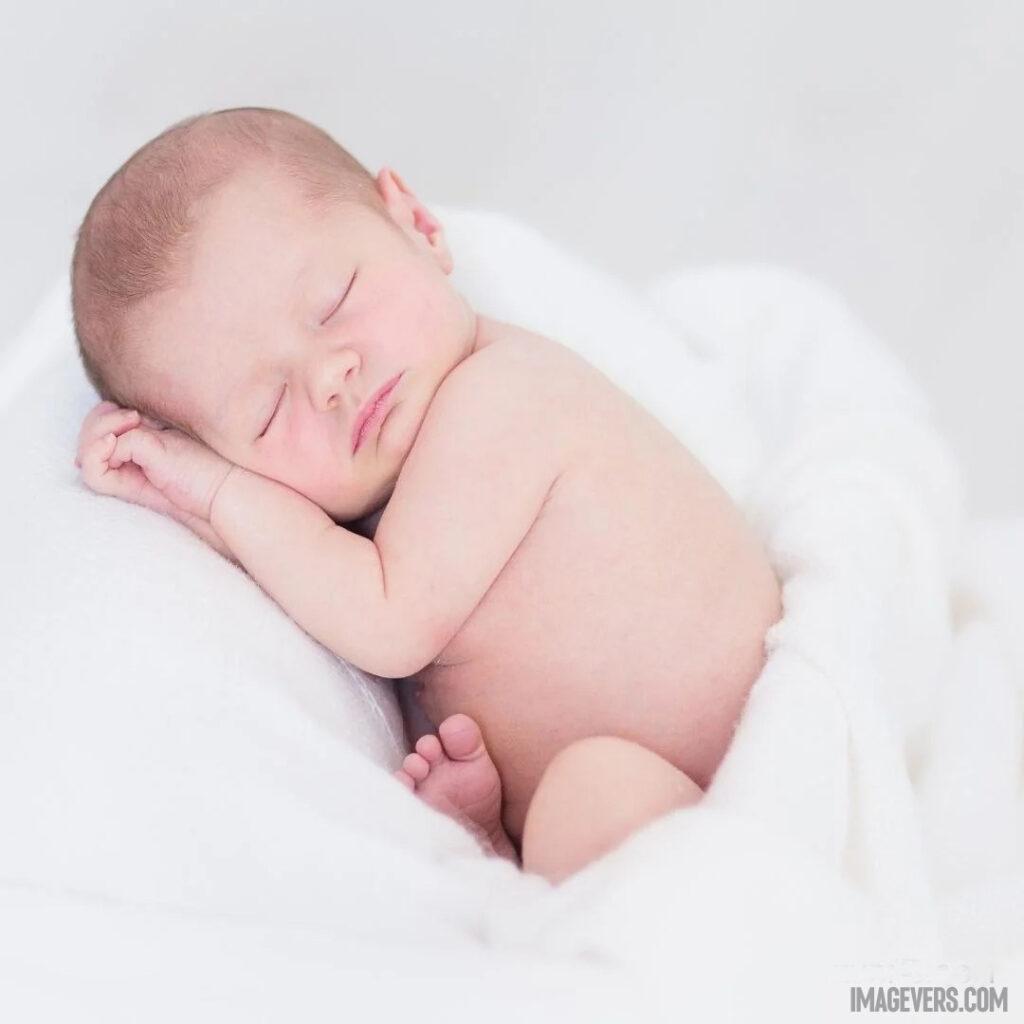 A newborn baby is sleeping on a white blanket with both hands folded together and head on top of it.jpg 3 11zon