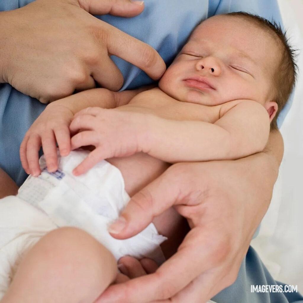 A newborn baby is sleeping on someones lap wearing mamy poko pants.jpg 7 11zon