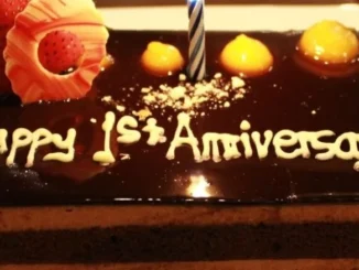 First-anniversary-cake-along-with-a-candle-is-decorated-with-fresh-strawberry-with-dark-chocolate