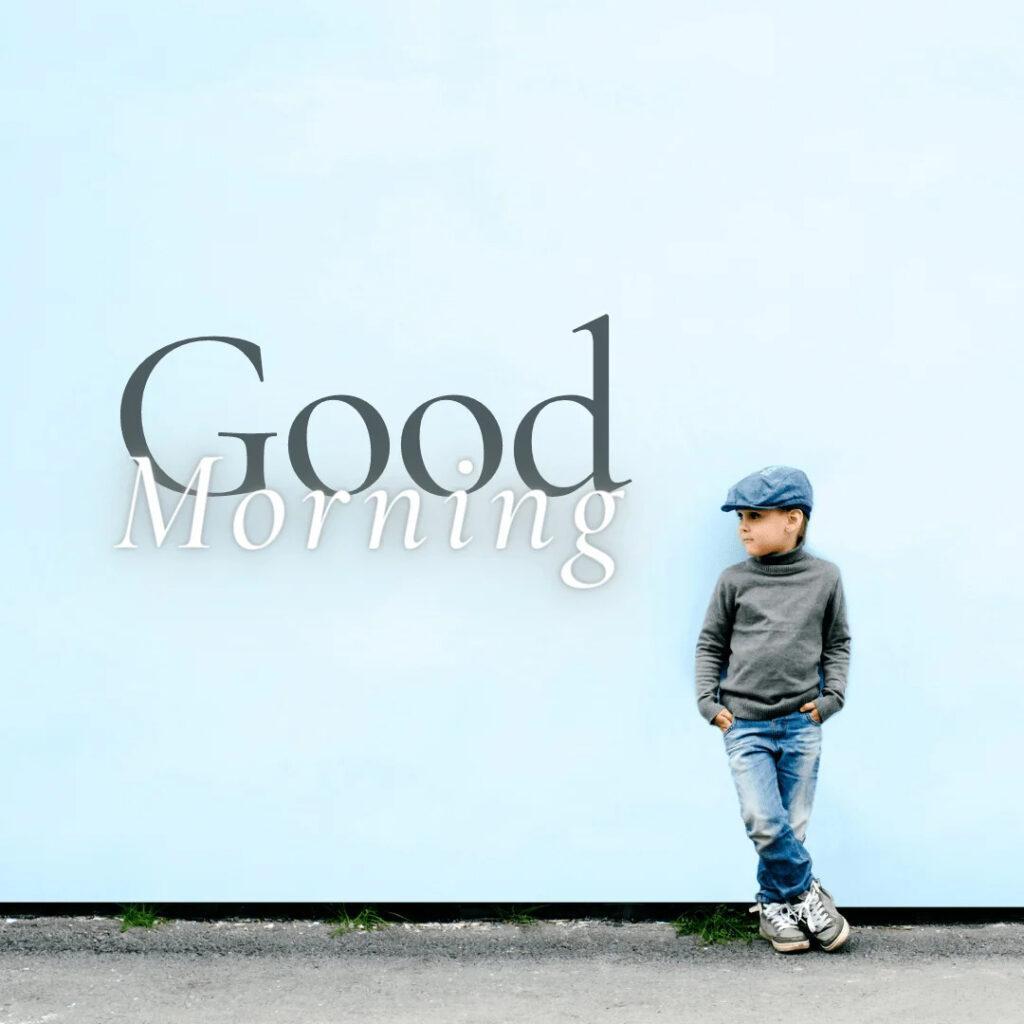 Smart kid wearing blue jeans and blue cap posing near the wall in the morning.png