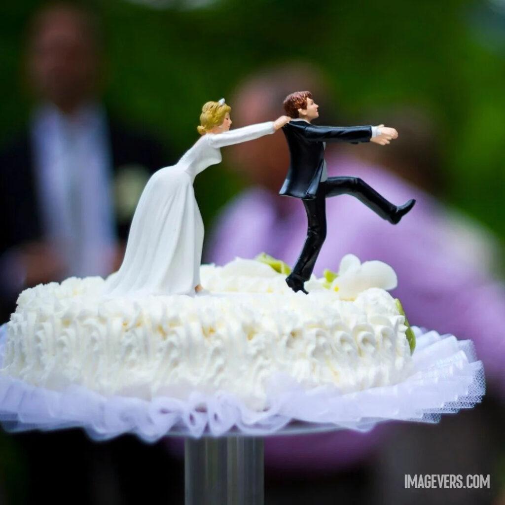 White frosting cream cake decorated for anniversary along with the statue of a couple.jpg