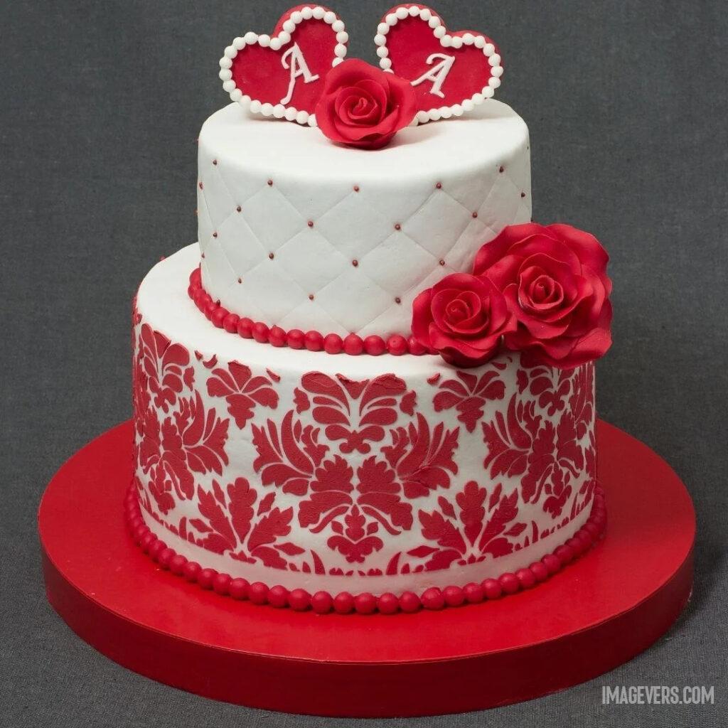 White layered cake decorated for anniversary with red roses and red shapes cream and placed on red stand.jpg