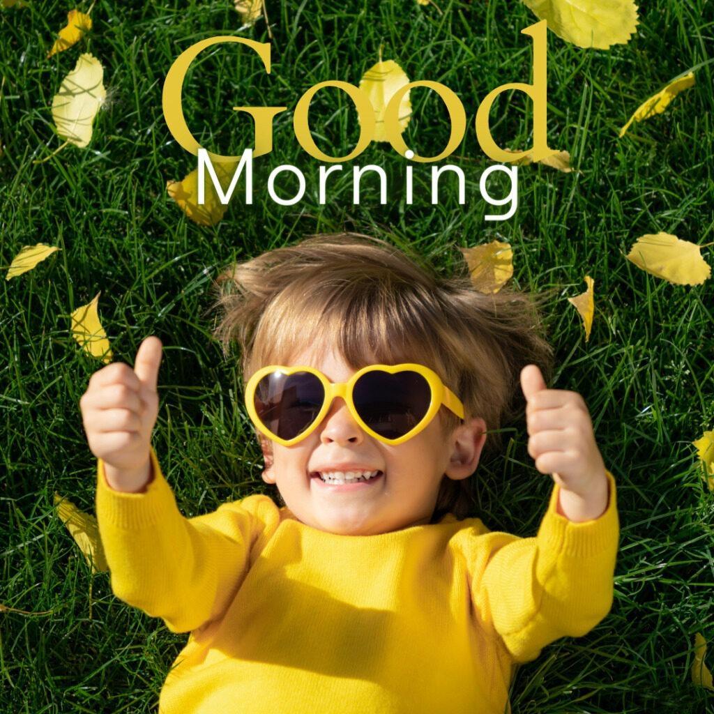 With Yellow heart shaped goggles and yellow top Kid Smiling and laying over grass in the early morning 1024x1024 1