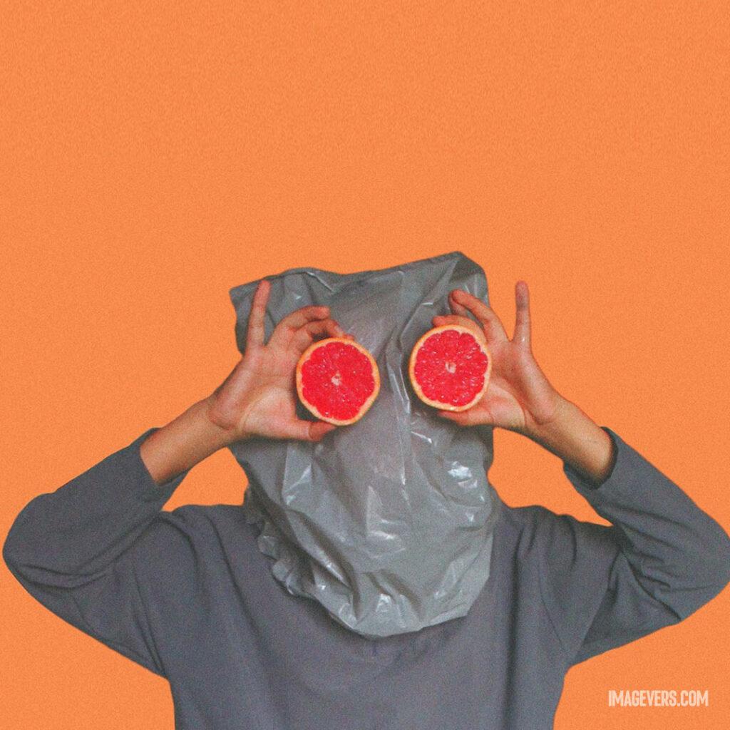 Person-Covered-With-Plastic-Bag-on-Head-While-Holding-Sliced-Blood-Orange